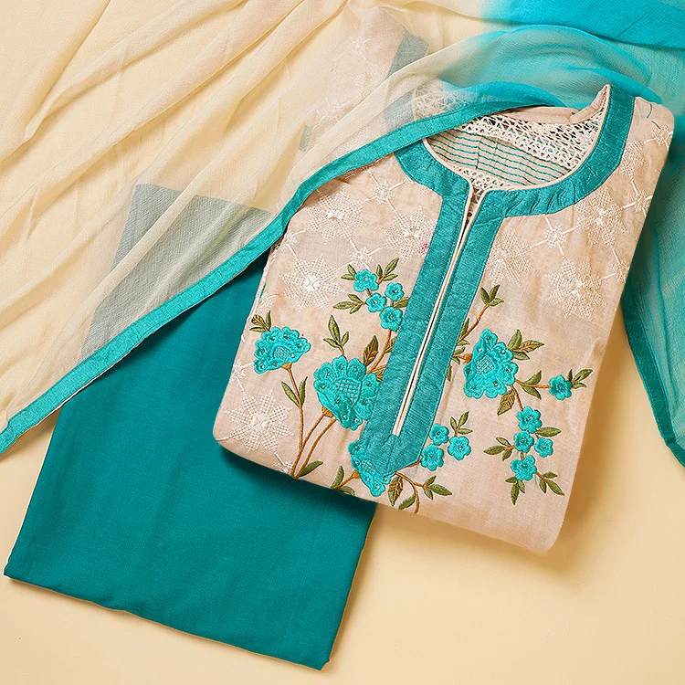 Overhead meesho flat lay photography of a peach cotton kurta with teal floral embroidery at the neckline, folded over matching teal pants and a sheer teal dupatta on a soft cream background, even shadow-free studio lighting