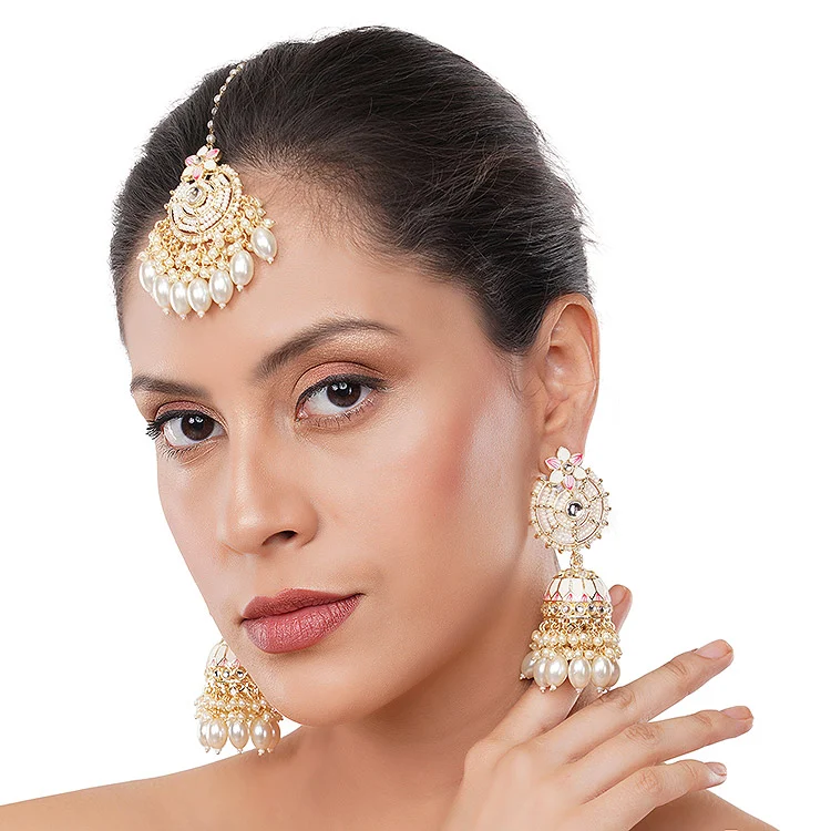 Indian female model with sleek hair bun wearing a pearl and kundan maang tikka with matching jhumka earrings, hand raised near her cheek on a clean white background, a square on-model scale image for jewellery listing tips