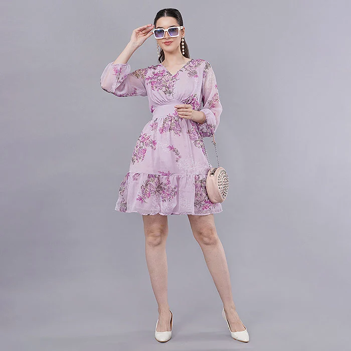 Indian female model in a lilac floral tiered mini dress with balloon sleeves, white sunglasses and a round woven bag, standing full length on a soft grey studio backdrop, clean catalogue lighting for a myntra m-now seller listing