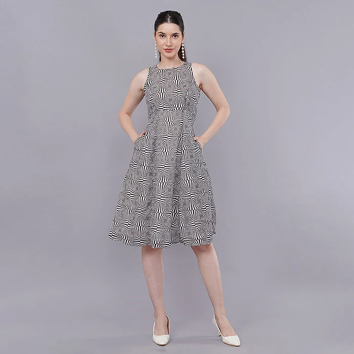 Front-facing full-length studio photo of an Indian model in a black and white printed sleeveless midi dress with hands resting lightly at the waist on a grey seamless backdrop, a relaxed straight front pose for ecommerce catalogue images