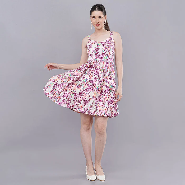 Indian model holding out the skirt of a pink paisley print fit-and-flare dress on a grey studio backdrop to show flare and fabric movement, a movement pose used in on-model fashion catalogue photography