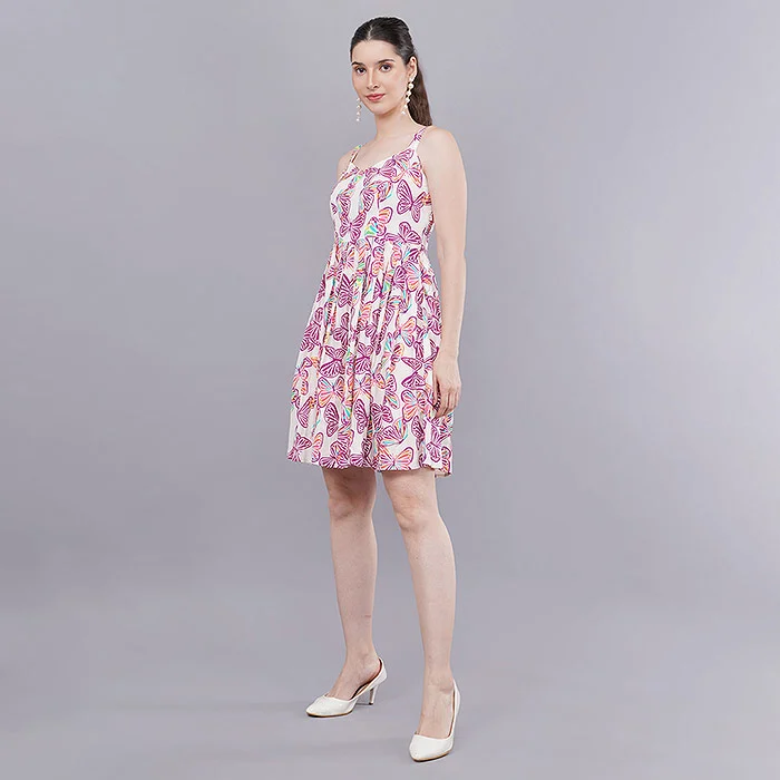 Front-facing on-model catalogue photo of an Indian female model in a pink paisley print strappy mini dress and white heels on a light grey seamless studio backdrop, evenly lit full-length shot of the kind that clears a myntra pmr hold