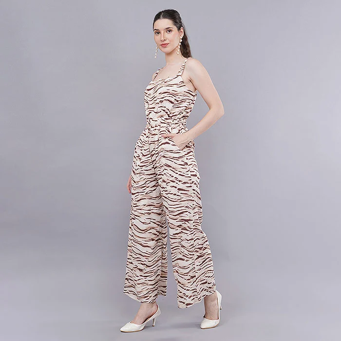 Full-length catalogue image of an Indian female model in a sleeveless zebra-print wide-leg jumpsuit and white heels on a light grey seamless backdrop, even soft lighting showing true fabric pattern for myntra quick commerce