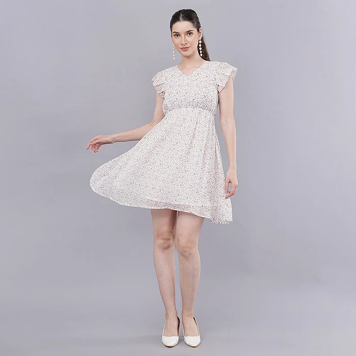 Indian female model twirling in a white floral chiffon fit-and-flare mini dress with flutter sleeves on a grey studio backdrop, movement shot that shows fabric flow and length to set honest expectations and reduce Meesho returns