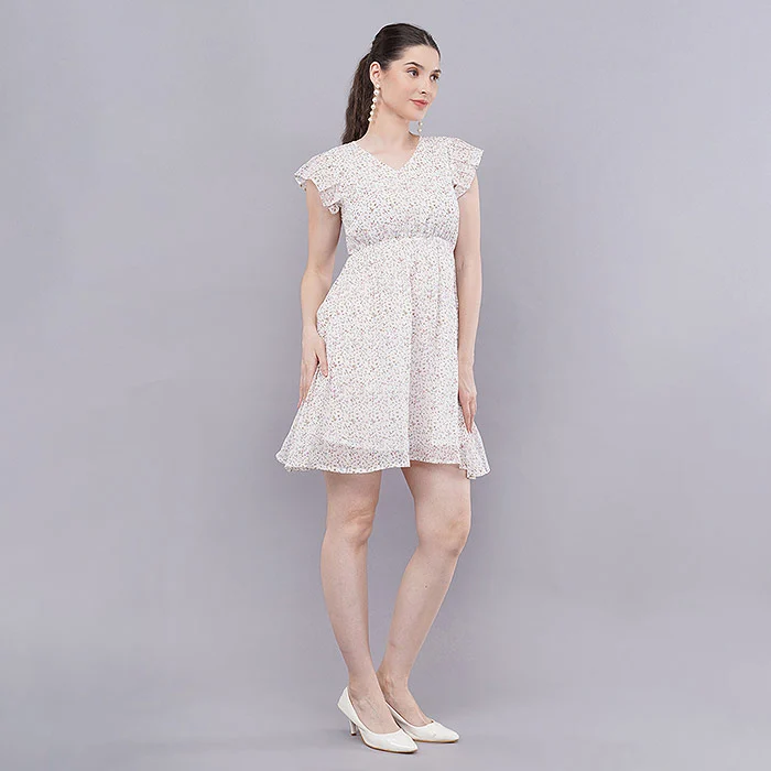 Meesho catalogue photography of an Indian female model in a white embroidered flutter-sleeve mini dress and nude heels, standing straight in a full-length front pose against a seamless light grey studio backdrop with soft even lighting