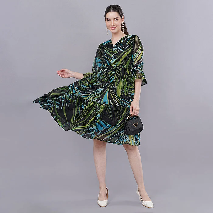 Indian female model twirling in a green and black tropical print tiered dress on a soft grey studio backdrop, captured mid-movement for an ecommerce product video cost comparison between still images and motion