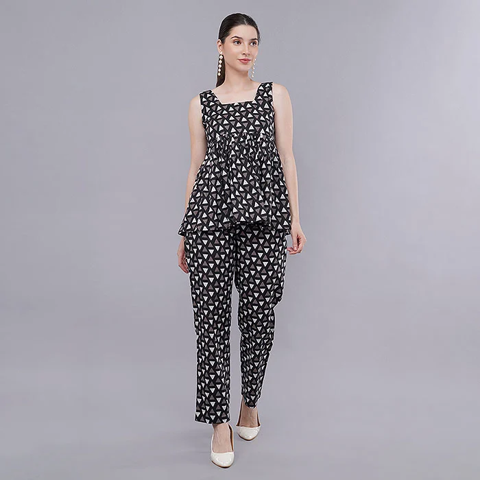 Indian female model in a black and white printed peplum top and matching trousers co-ord set standing on a light grey studio backdrop with white heels, balanced lighting keeping true blacks and clean whites for consistent catalogue colour