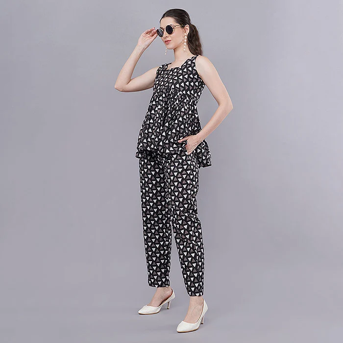 Indian model in a black and white polka dot sleeveless peplum top and matching trousers co-ord set wearing sunglasses on a grey studio backdrop, a styled full-length co-ord frame from a size inclusive catalogue shot list