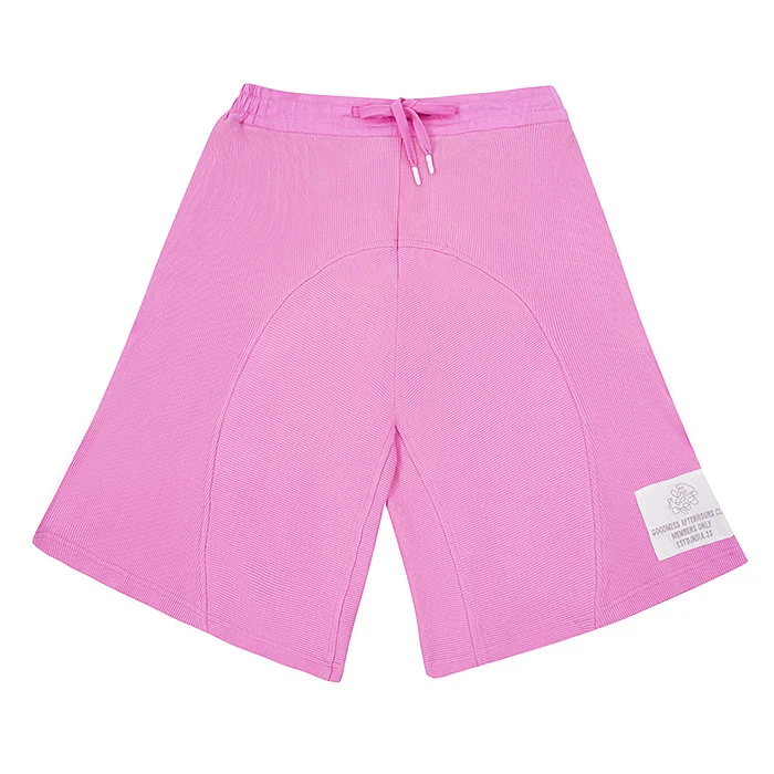 Bright pink drawstring kids' shorts with a woven label photographed flat on a white background, a steamed and tag-free sample ready for a kids clothing photoshoot