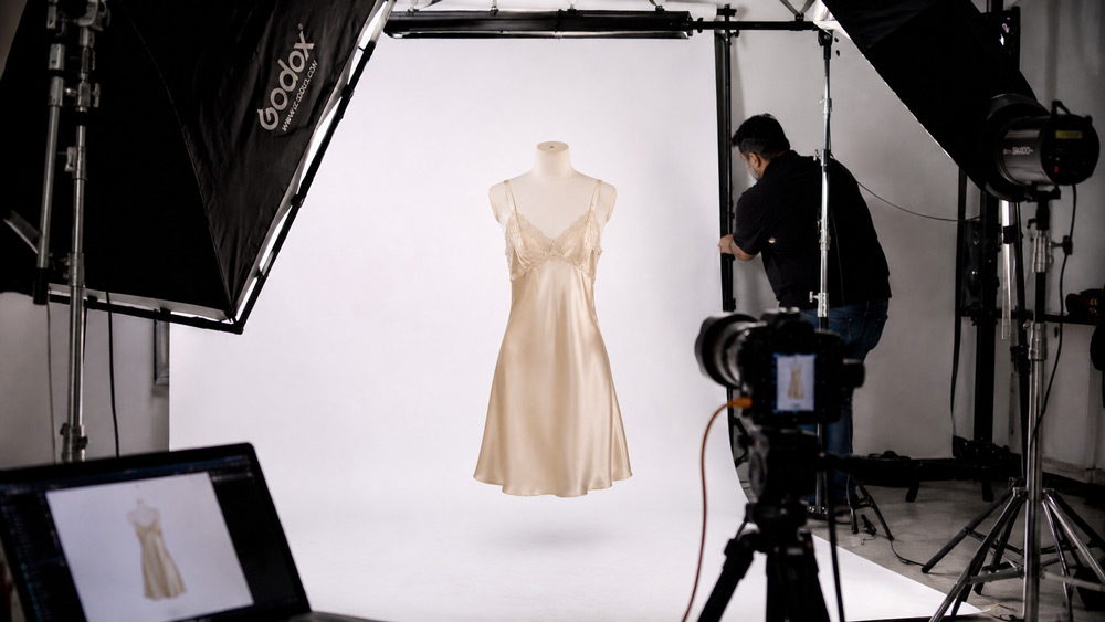 Editorial 3D ghost mannequin product photography of a champagne silk chemise floating on pure white background with soft shadow beneath showing invisible dressform effect for intimate apparel ecommerce catalog Delhi NCR India