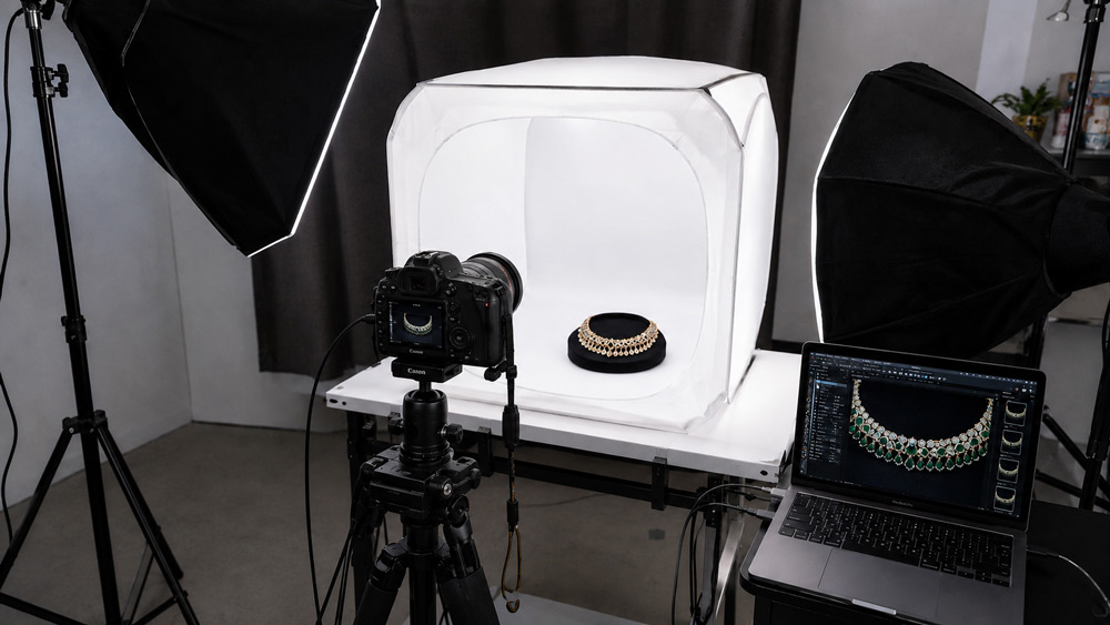 Professional jewellery photographer in Delhi NCR shooting tethered macro images inside a controlled studio setup with light tent and softbox lighting