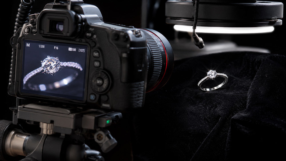 Professional macro photography setup for jewellery at Uniqs Studio showing full-frame mirrorless camera on carbon fibre tripod with focus rail and softbox diffusion — behind the scenes Delhi NCR studio