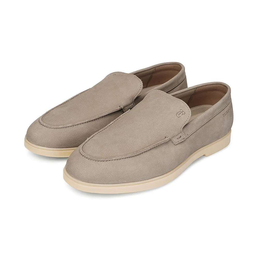 Pair of taupe suede slip-on loafers with cream rubber soles shot at a three-quarter angle on a pure white background with soft shadow, crisp texture detail for a fast-delivery footwear listing